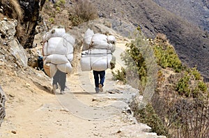 Two sherpa porters carrying heavy sacks,Himalaya,Everest region