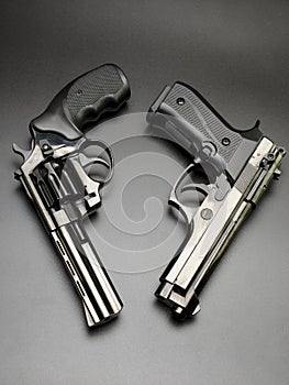 Two shiny black pistols on a black background