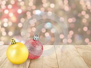 two shiny christmas ball on wooden plank table top with defocused colorful lights bokeh on christmas tree