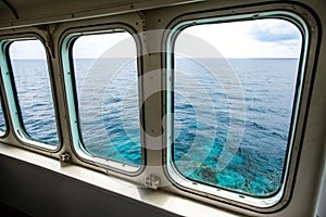 Two ship windows with ocean surface and underwater deep