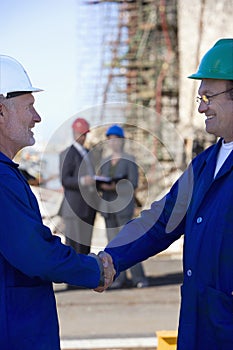 Two shipping engineers shaking hands