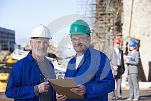 Two shipping engineers taking notes