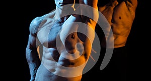 Two shirtless hunks at black background. Close up of an athletic guy with perfect abs. Hunky shirtless male model photo