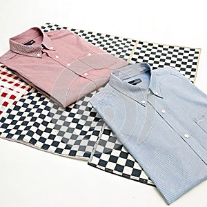 Two shirts on a checkered surface isolated on white background