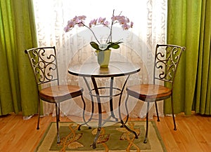 Two shod chairs and little table about a window of a modern classical drawing room