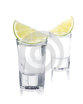 Two shots of vodka and lime slice
