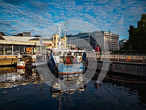 two shrimp boats moored on a pier on a city wharf in the morning