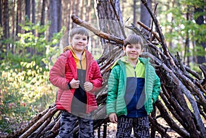 Two sibling brothers boys In the spring or autumn pine forest pl