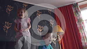 Two siblings jumping on double size bed