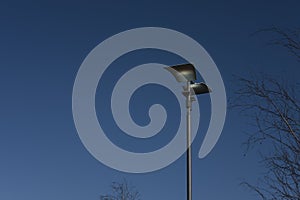 Two sided modern street lamp with dark steel blue sky background photo