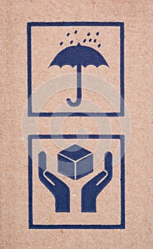 Two signs on cardboard box - Umbrella and Handle with Care