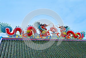 Two silhouette chinese dragon at the roof temple with blue sky