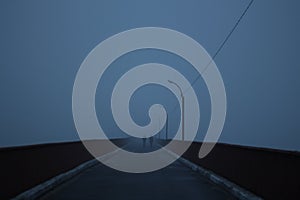 Two silhouettes in the fog reaching over the bridge