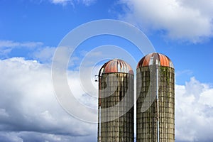 Two Silos against a partically cloudy sky photo