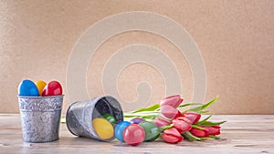 Two silver goblets with colorful easter eggs and red tulips