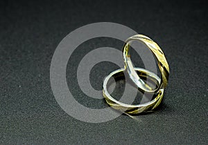 Two silver and golden wedding rings isolated on a black background