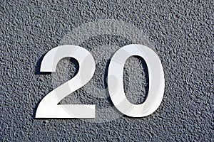 Two silver metallic digits fixed on a wall and showing the number twenty