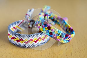Two simple handmade homemade natural woven bracelets of friendship on wooden table