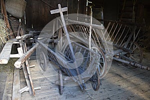 Two simple vintage horse-drawn wooden hay-wagons with simple cart-ladder sides.