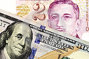 A two Singapore dollar bill with a new American one hundred dollar bill