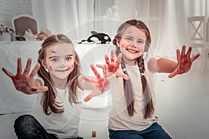 Two sister showing his hands covered in paint photo