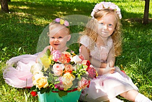 Two sisters. Adorable little child girls with bouquet of flowers on happy birthday.