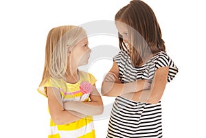 Two sisters with arms folded angry looking at each
