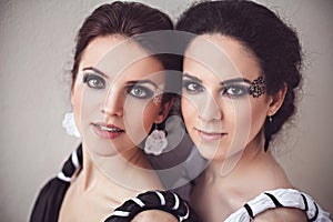 Two sisters with black and white fantasy make-up photo