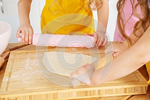 Two sisters of Caucasian appearance prepare cookies in the kitchen