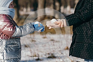 Two sisters of different ages on a winter walk in a snowy park