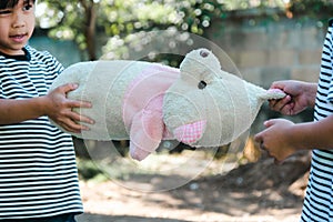 Two sisters in a dispute over a toy at home. Sibling girls snatching doll while stay at home. Relationships difficulties in family