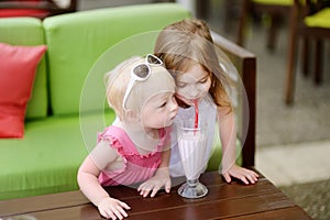 Two sisters drinking milkshake