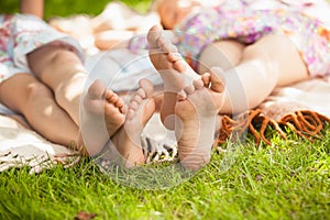 Two sisters feet lying on grass at park