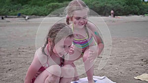 Two sisters girls play on the beach. Family holidays by the sea