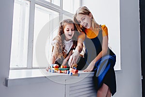 Two sisters having fun. Playing with toy train. Togertherness and friendship