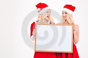 Two sisters holding blank board and looking on each other