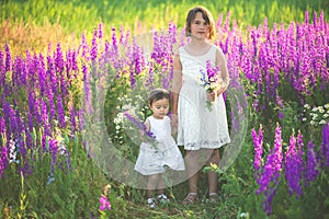 Two sisters holding hands in the flower chain in summer