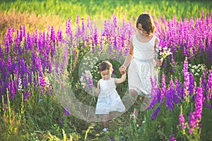 Two sisters holding hands in the flower chain in summer