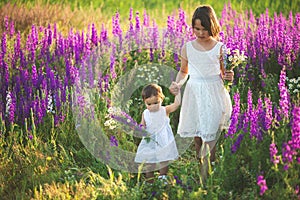 Two sisters holding hands in the flower chain in summer