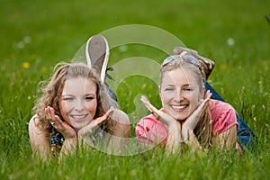 Two sisters lay on the grass