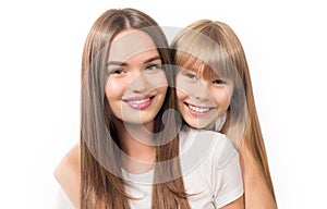 Two sisters - older and younger together. Portrait of beautiful young sisters teenage and adult girls hugging and smiling together