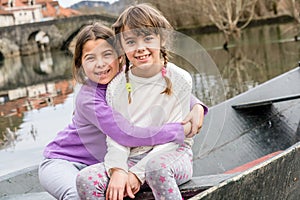 Two sisters sitting in the boat and hugging