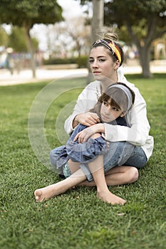 Two sisters sitting with very serious faces.