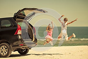 Two sisters standing near a car on the beach