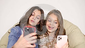 Two sisters take selfies at home, smiling friends taking a self shot with phone