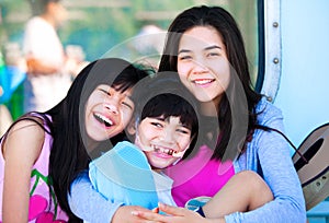 Two sisters taking care of disabled little brother