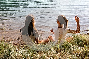 Two sisters trowing stones into the lake