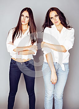 Two sisters twins posing, making photo selfie, dressed same whit