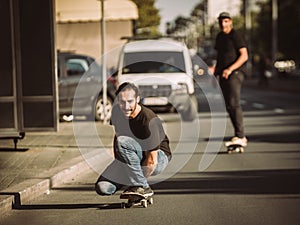 Two skateboarders ride a skateboard slope in the city street