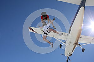 Two skydivers exit an airplane